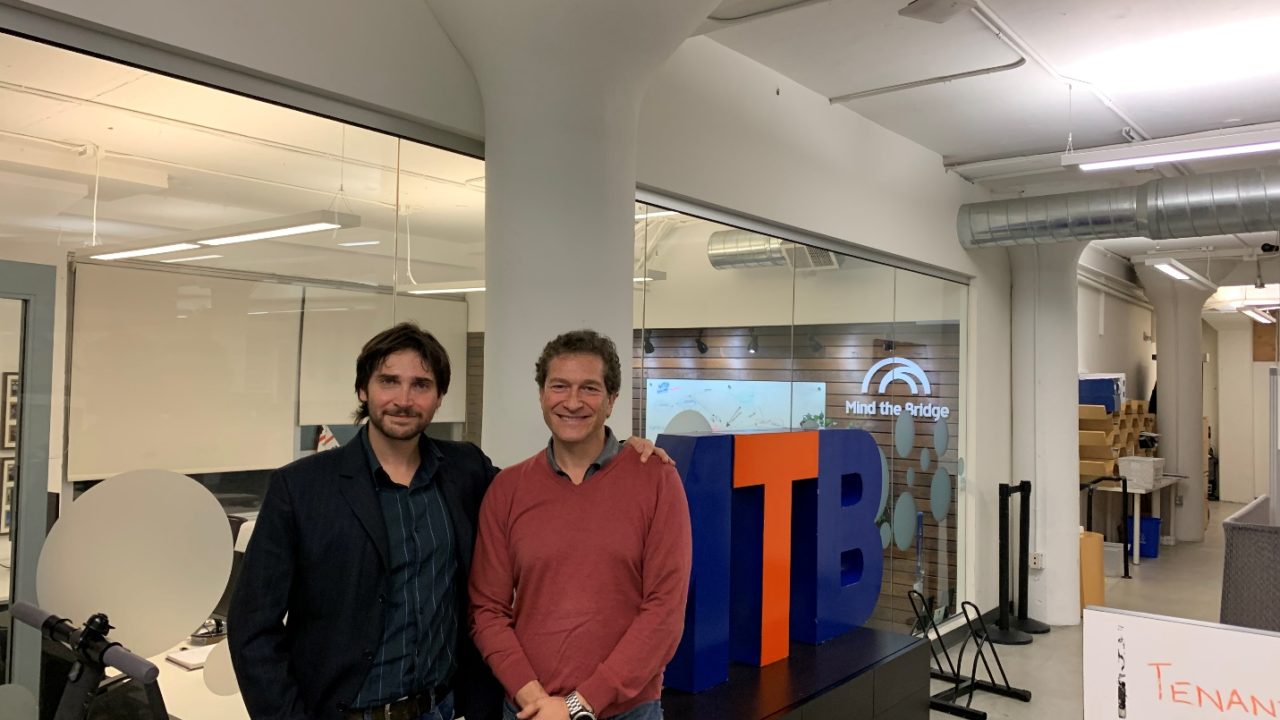 A couple of men posing for a picture Description automatically generated with low confidence